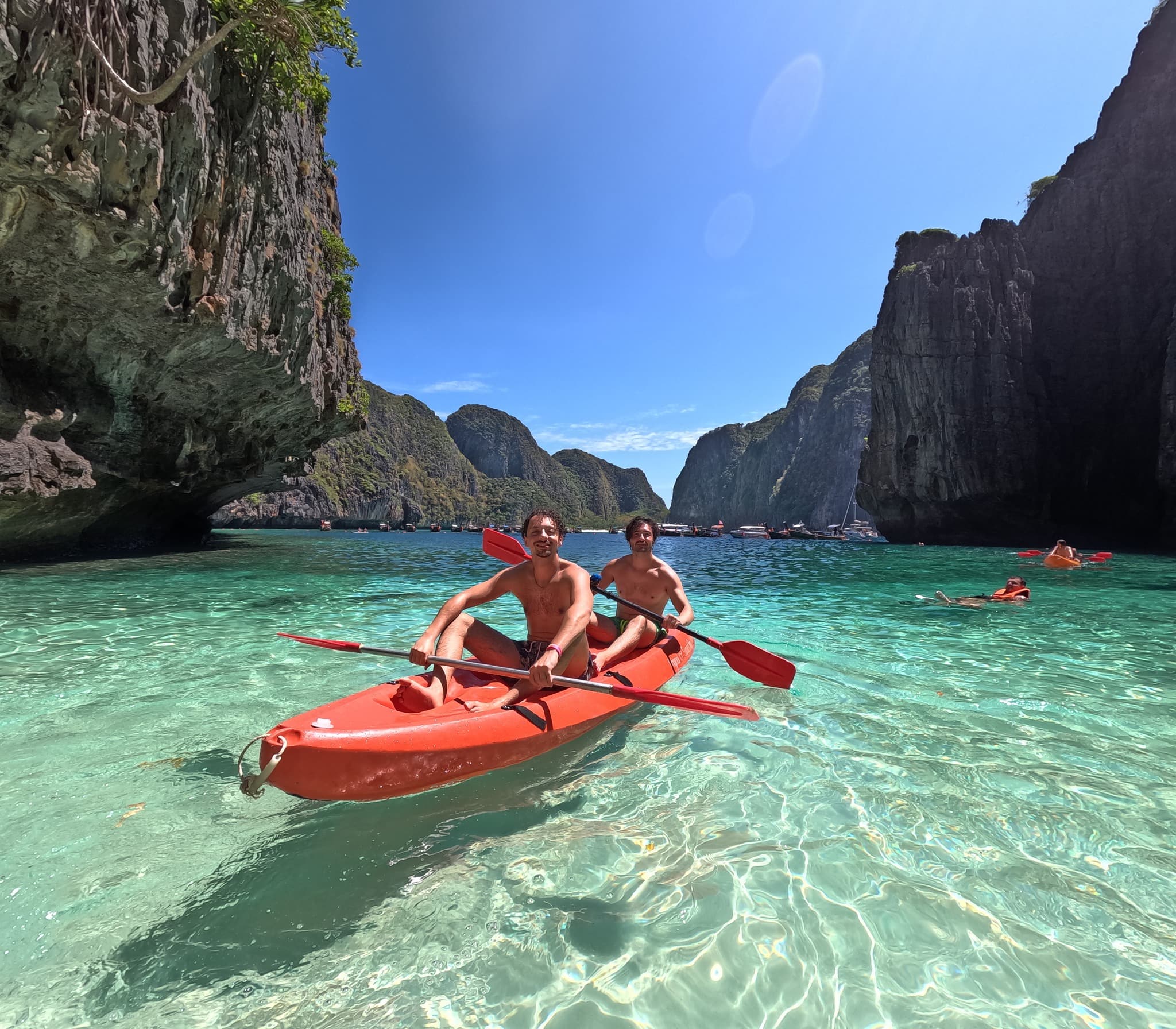 Kayaking on clear turquoise water under the cliffs